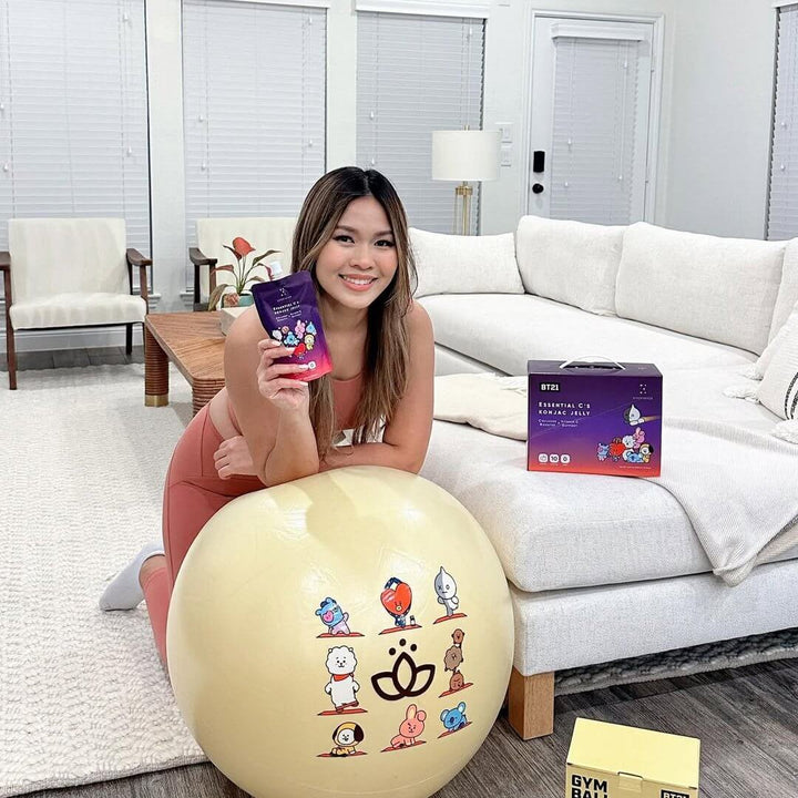 Essential C’S Konjac Jelly Vitamin held by a woman on a balance ball in a cozy living room.