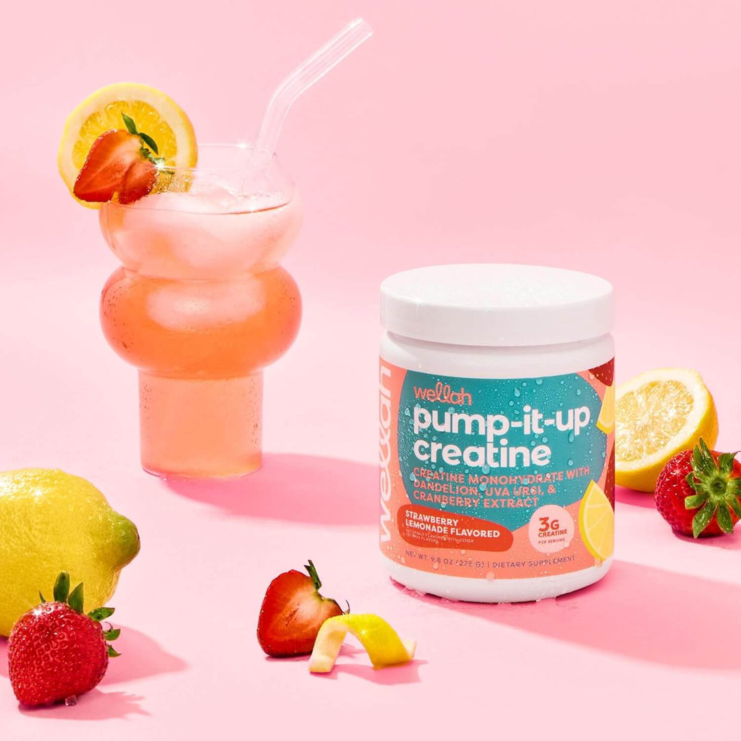 Pump It up Creatine supplement with strawberry flavor, next to a refreshing drink and fresh fruits.
