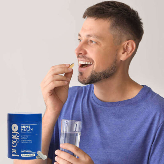 Man taking dietary supplement for men's health with a glass of water and a container of Preggo vitamins.